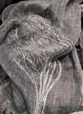 Close-up of a big hand stitched tree ion a black and white two tone linen scarf. 