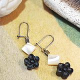 Close-up of feminine black sandal wood crafted Chinese blossom flower tiny white square mother-of-shell 925 silver dangle earrings 