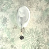 Graceful sterling silver earrings in black sandal wood Chinese blossom flower and delicate white square mother-of-shell display on ear model

