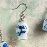 Close-up on 925 silver ear wire dangle earring in traditional chinese blue white ceramic vase with hand painted chrysanthemum patterns 
