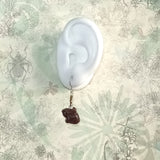 mini red sandal wood crafted Chinese  rabbit sterling silver ear wire dangle earrings displayed on a white ear model 