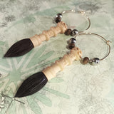 Close-up of two box wood crafted chinese calligraphy brush in sandal wood tip hoop copper earrings 
