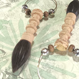 Close-up of two box wood crafted traditional chinese writing brush of copper hoop earrings, enriched by wood and silvery beads.