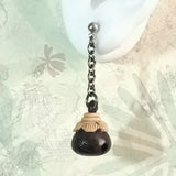 Close-up display of silver drop earrings ebony wood oriental dingle bell in eggplant form,  elongate by dart metal chain, an aroma diffuser