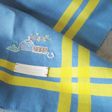 Close-up of sky blue pure cotton handkerchief, yellow stripes, and the lovely hand stitch night supper motif. 