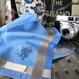 Exquisite sky blue pure cotton hanky with two silver grey stripes as border, featured a detailed hand embroider of a flying airplane and an old village in the wood