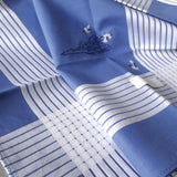 Close-up of sky blue cotton hanky with nine white stripes border, hand stitched chinese lucky cloud pattern and three vivid oriental white storks