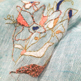 Close up of a big hand embroidery abstract pattern of different color and metal threads, forms a line art of dancing flowers.