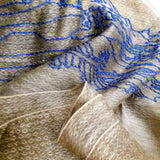 Close up of light weight olive color silk wool scarf has embroidered a big blue line art landscape pattern combine of ancient Chinese village and  power towers on the hills