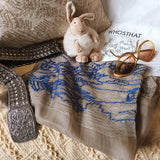 Sheer textured olive color silk wool scarf has a big line art embroidery of landscape scenery compose of old Chinese cottage, low bush, livestock and rivers.