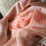 Close up of light weight pink silk wool shawl has embroidered a big orange line art landscape pattern in Chinese traditinoal style.