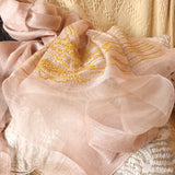 Soft coral color silk wool sheer scarf is embroidered a big line art pattern of chinese style scenery of old chinese lodge, groves, livestocks and streams.