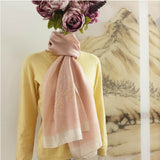 A feminine silk wool scarf in salmon pink color, is hand embroidered a bunch of magnolia plant and an tiny elf playing swing, match well with yellow sweater.