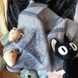 grey tone scarf decorated with white fine lines has a big line thread drawing of an ancient chinese ornament in blue color