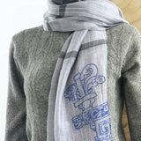 close-up of gray light weight long scarf with white fine stripes and dark grey border hand stitched chinese ancient pattern 