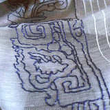 Close-up of light weight soft scarf in grey color with white pin-stripes,  hand embroidered an ancient chinese bucket arch in bold stitches