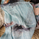 Light blue two-tone pure linen scarf with a hand-embroidered swirl pattern and multi-color hand felted wool landscape