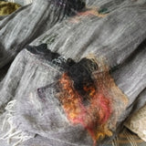 A black and white two-tone weave linen scarf with hand twisted tassel hem , hand embroidered and hand felted surreal landscape of chinese huts, trees in black, red, and orange color. 