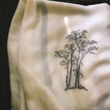 Light beige 300s super fine cashmere shawl is hand embroidered a big pattern of white blossom tree with a cat resting the bottom.