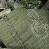 Top view of a pickle green window-plaid linen shawl with a line art embroidery in white color delineate the scenery of a Chinese poem