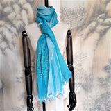 Turquoise color pure linen scarf with hand twisted tassels features a line art embroidery design of a spaceman getting lost in an old village. 