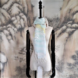 A light weight cotton linen scarf in light yellow and icy blue color stripes has a white straw tape embroidered pine trees pattern and fringe at the hem.