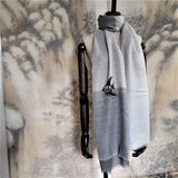 A light grey tone 300s super fine cashmere shawl with a pencil drawing  style hand embroidery of a swimming angelfish, display on a mannequin