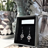 A pair of Star of David 925 silver ear wire dangle earrings displayed in a paper gift box 